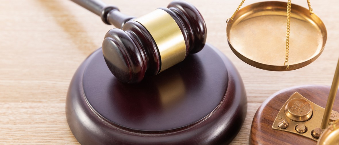 A high angle shot of a gavel and a scale on a wooden surface