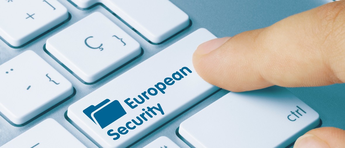 European Security Written on Blue Key of Metallic Keyboard. Finger pressing key.
