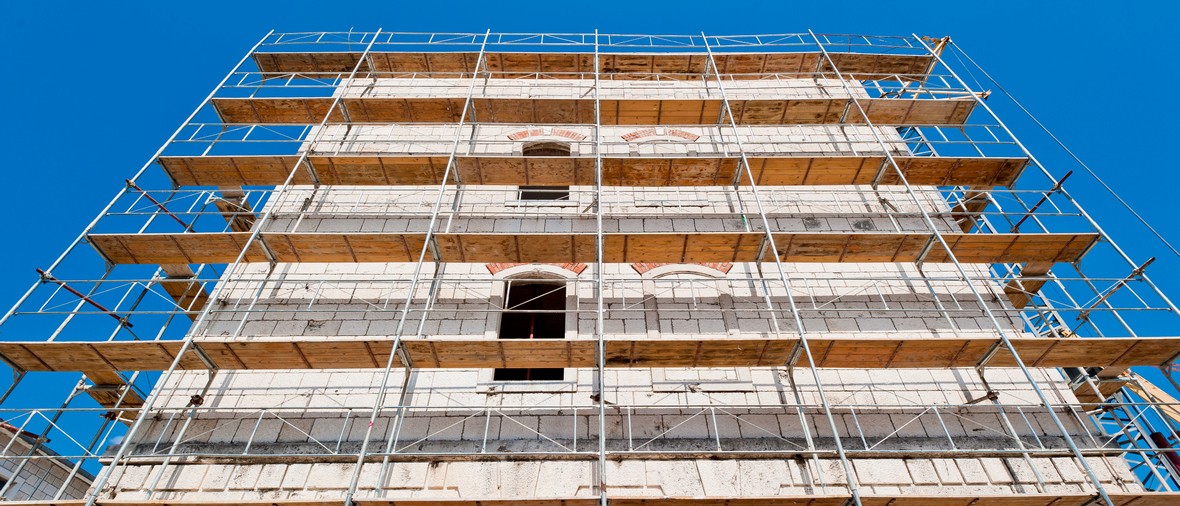 old building during reconstruction with wooden scaffolding viewed from below