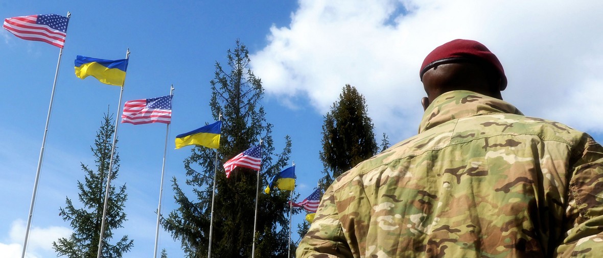 American Soldiers and flags of the Ukraine and USA at background. US military help to Ukraine.