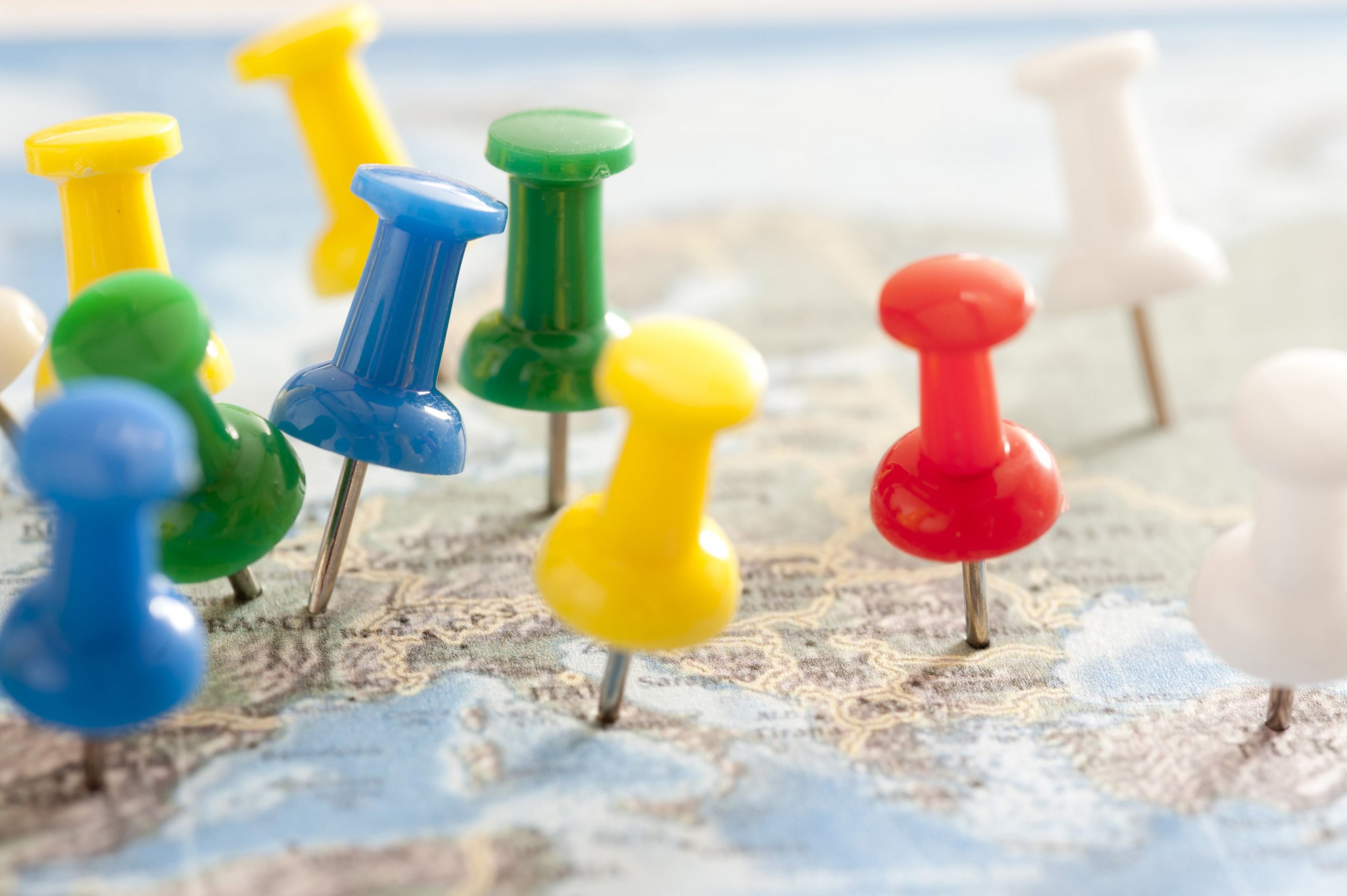 Close Up of Multi-Colored Thumb Tacks Inserted in Various Locations in Europe Map