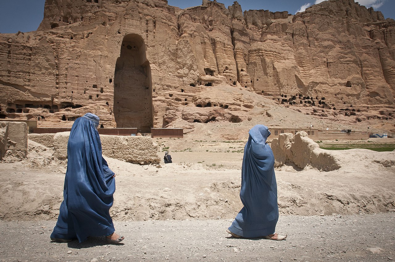 BAMYAN PROVINCE, Afghanistan - Two women walk past the huge cavity where one of the ancient Buddhas of Bamiyan, known to locals as the 