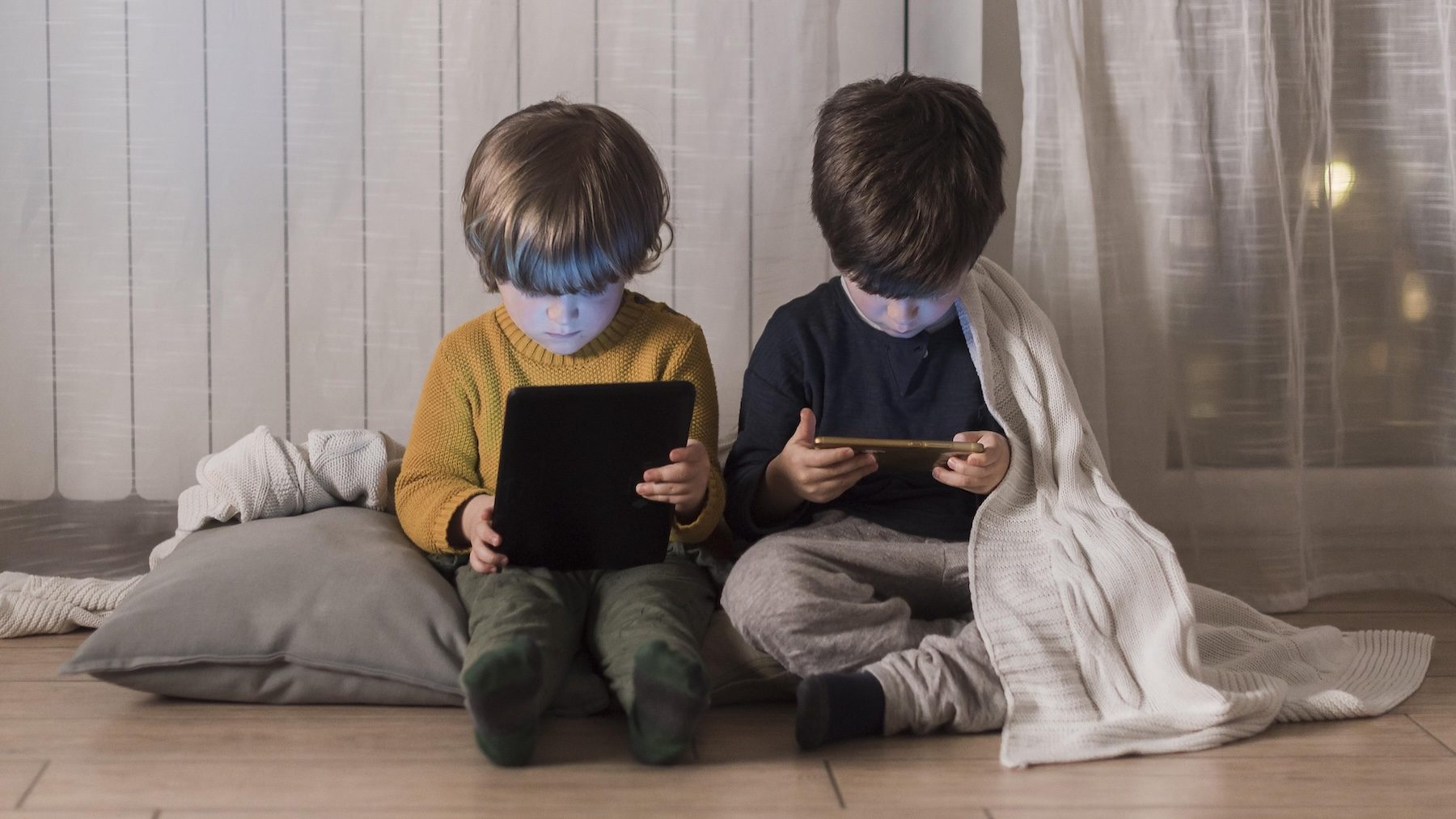 full-shot-kids-sitting-with-devices 2